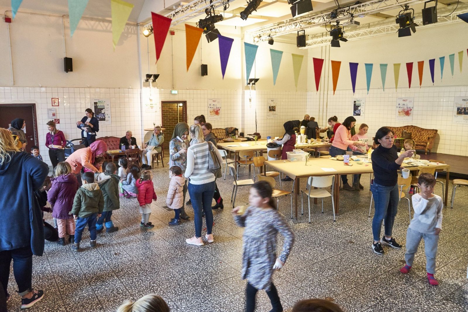 Verschiedenste Personen in Bezug auf Alter und Lesbarkeit bewegen sich in einem Raum