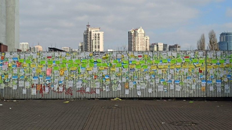 Lots of small sticky notes on a wall.