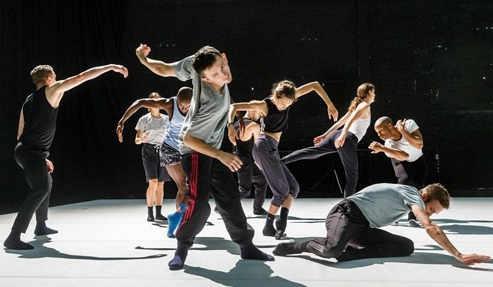 Several people dancing in flowing movements.