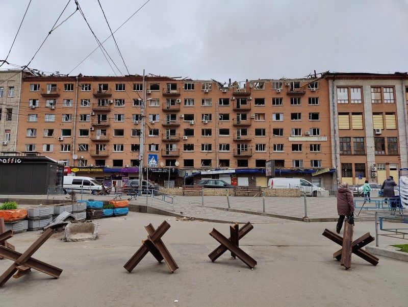 A multi-storey residential building with severe damage, destroyed windows and balconies.