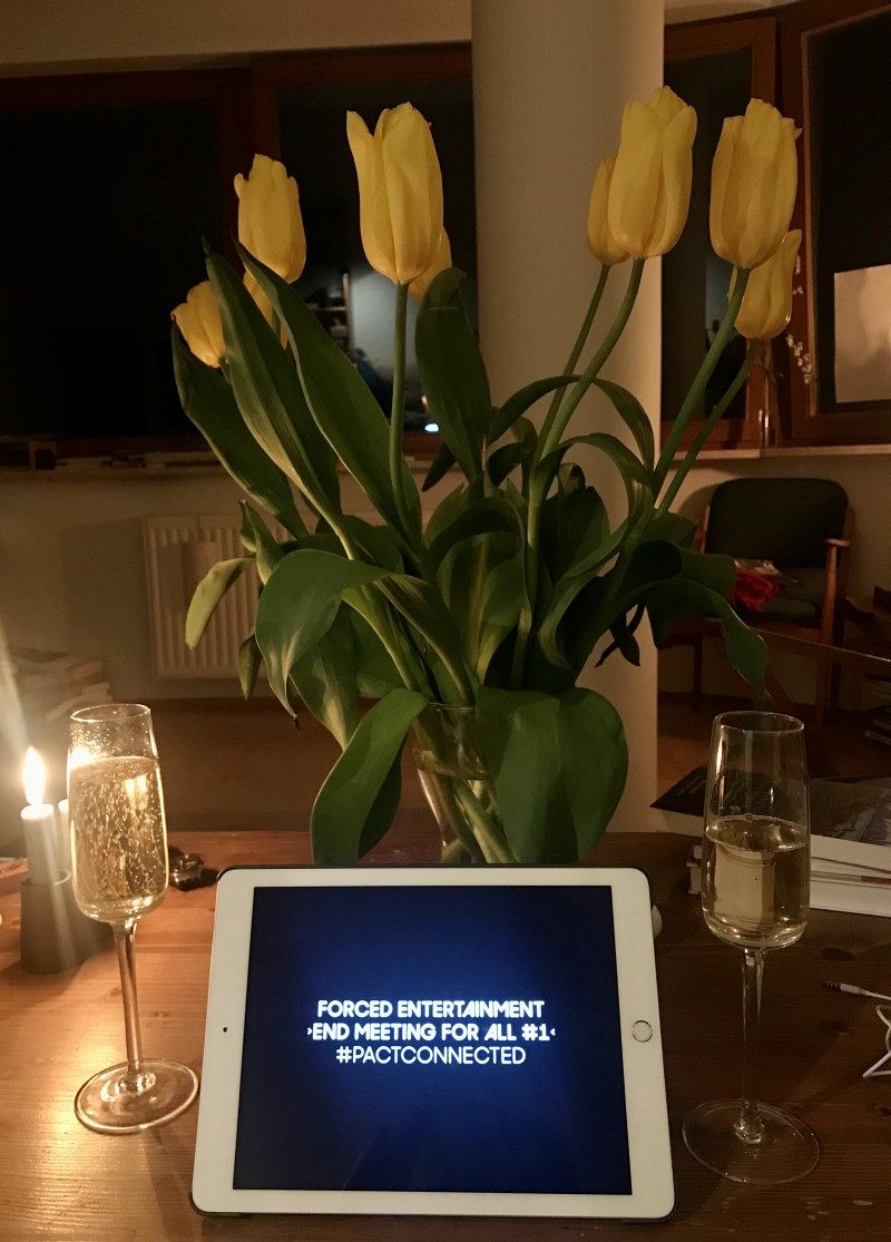 A bouquet of yellow tulips, two champagne glasses and a tray are placed on a table.