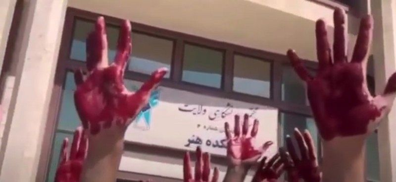 Einige Hände mit roter Farbe auf der Handfläche.