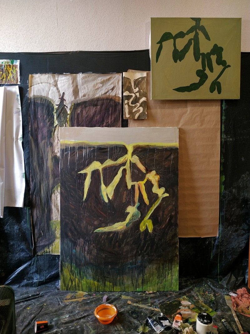 Some painted canvases leaning against a wall.