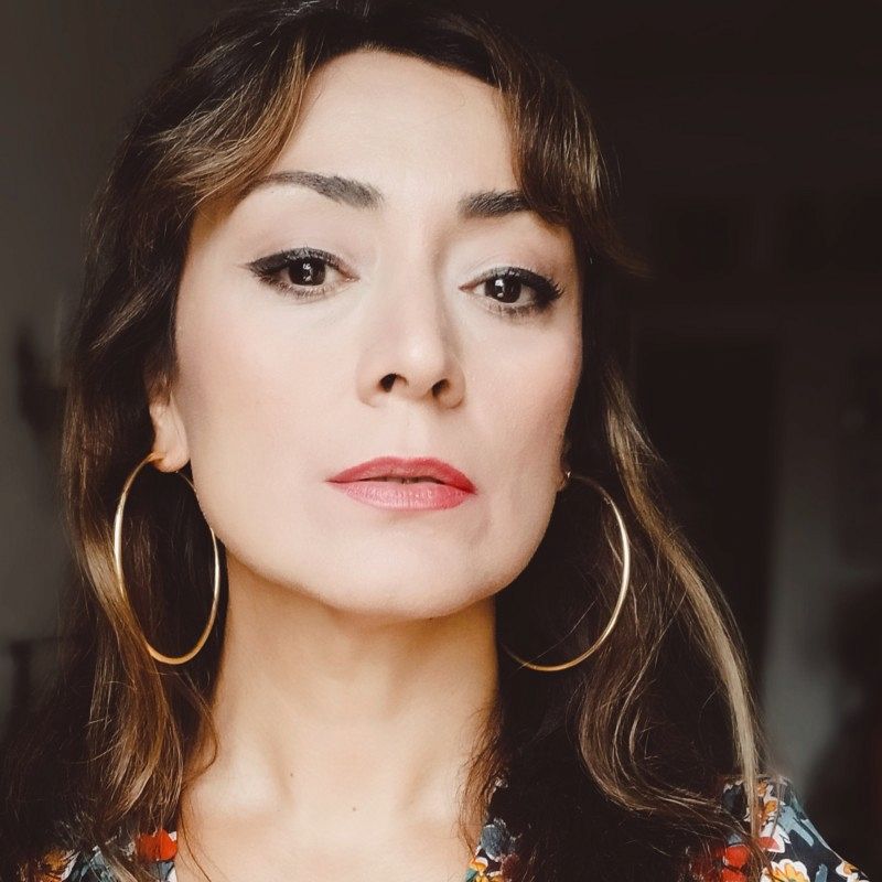 close-up photo of a woman wearing make-up and jewelry.