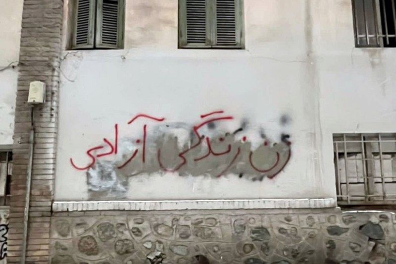 Graffitti in Farsi an einer Hauswand.