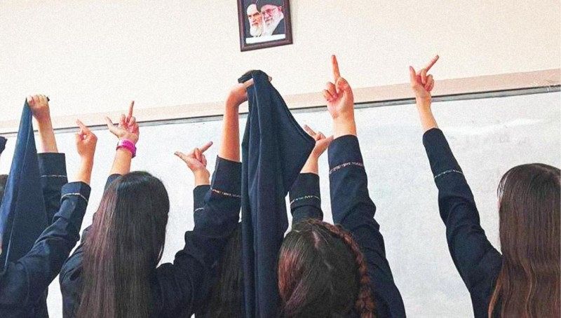 Women giving the middle finger to a picture of two men.