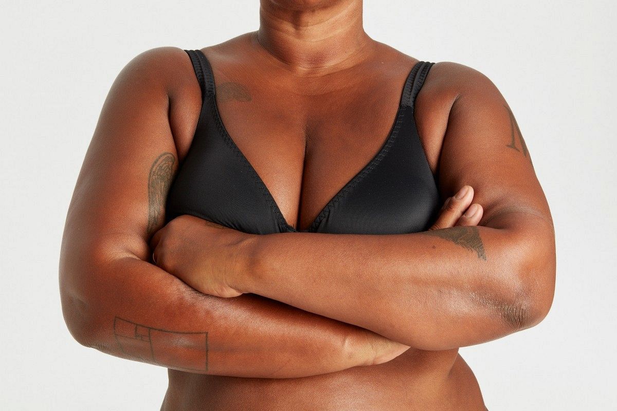 The upper body of a woman crossing her arms.